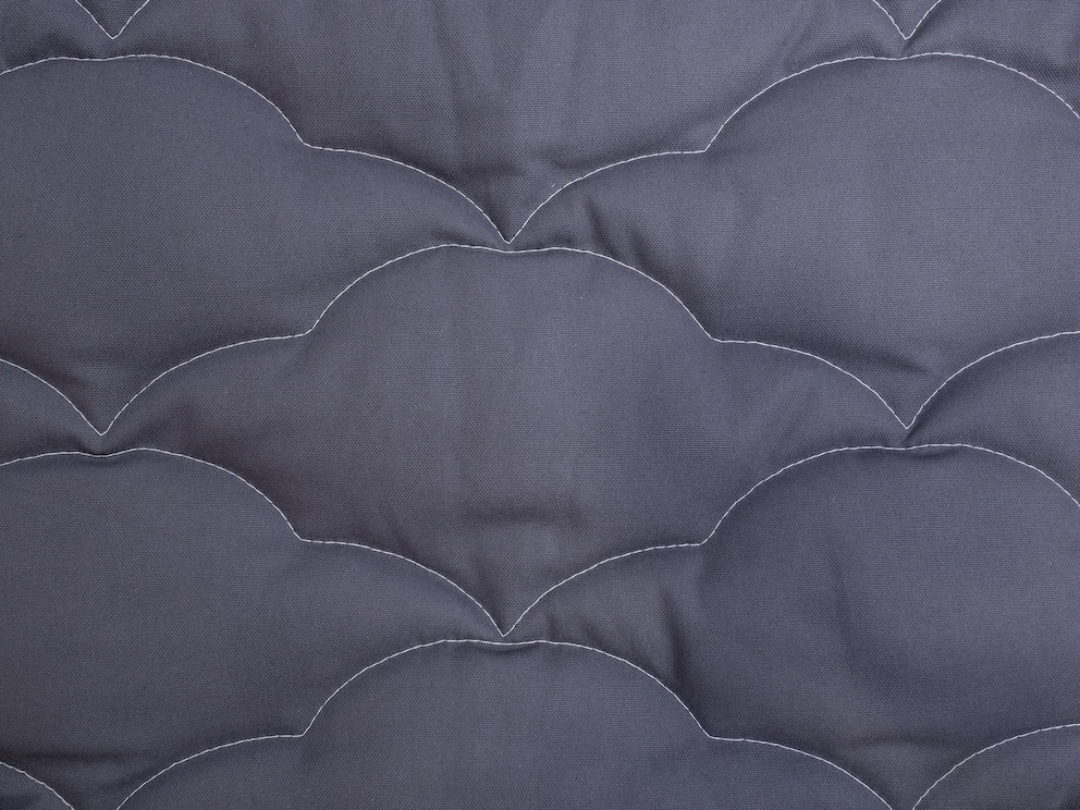 Les coutures piquées contrastantes soulignent le motif des nuages sur le tapis à langer couleur anthracite