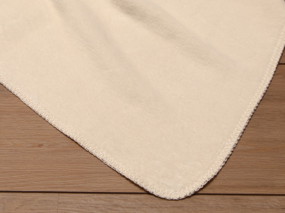 Le bord en crochet ludique souligne le crème naturel de cette couverture douillette intemporelle