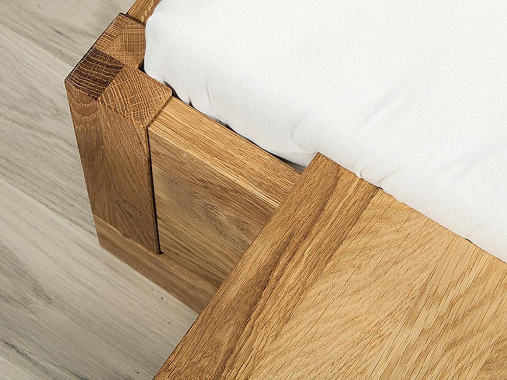 Les deux tables de nuit suspendues sont simplement accrochées sur le côté du lit
