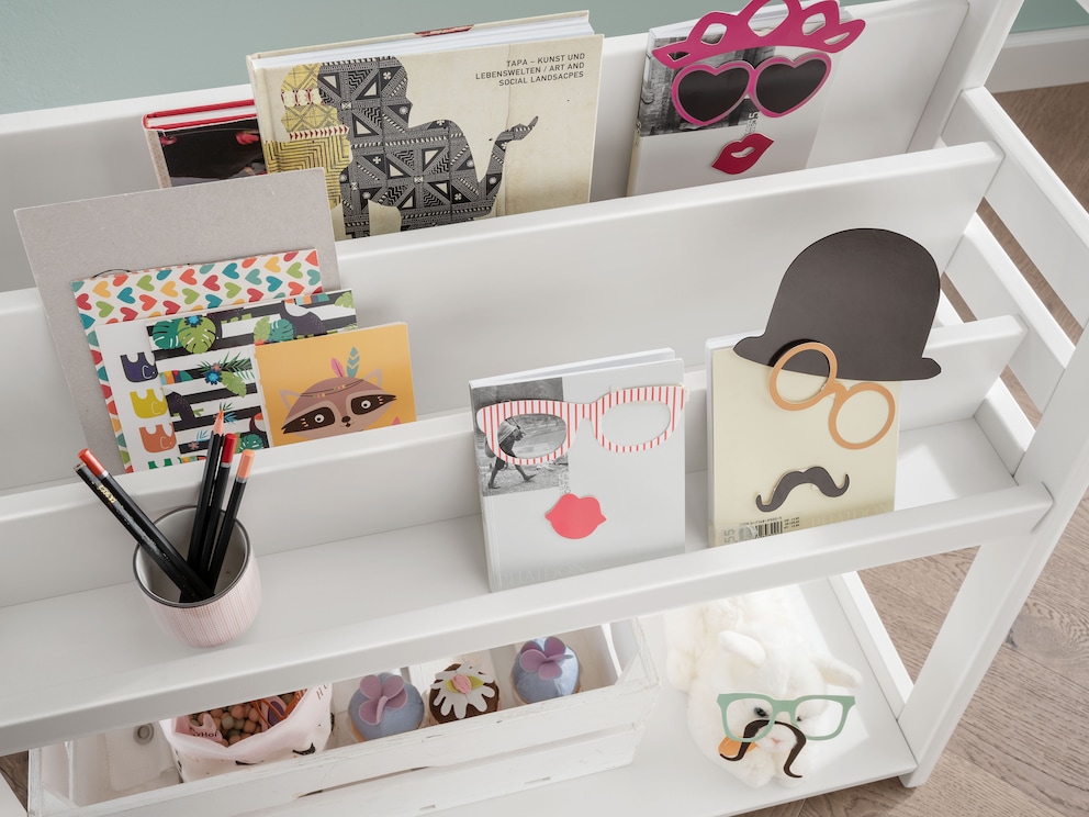 Dans le compartiment supérieur, les livres sont toujours à portée de main, ici en hêtre laqué blanc