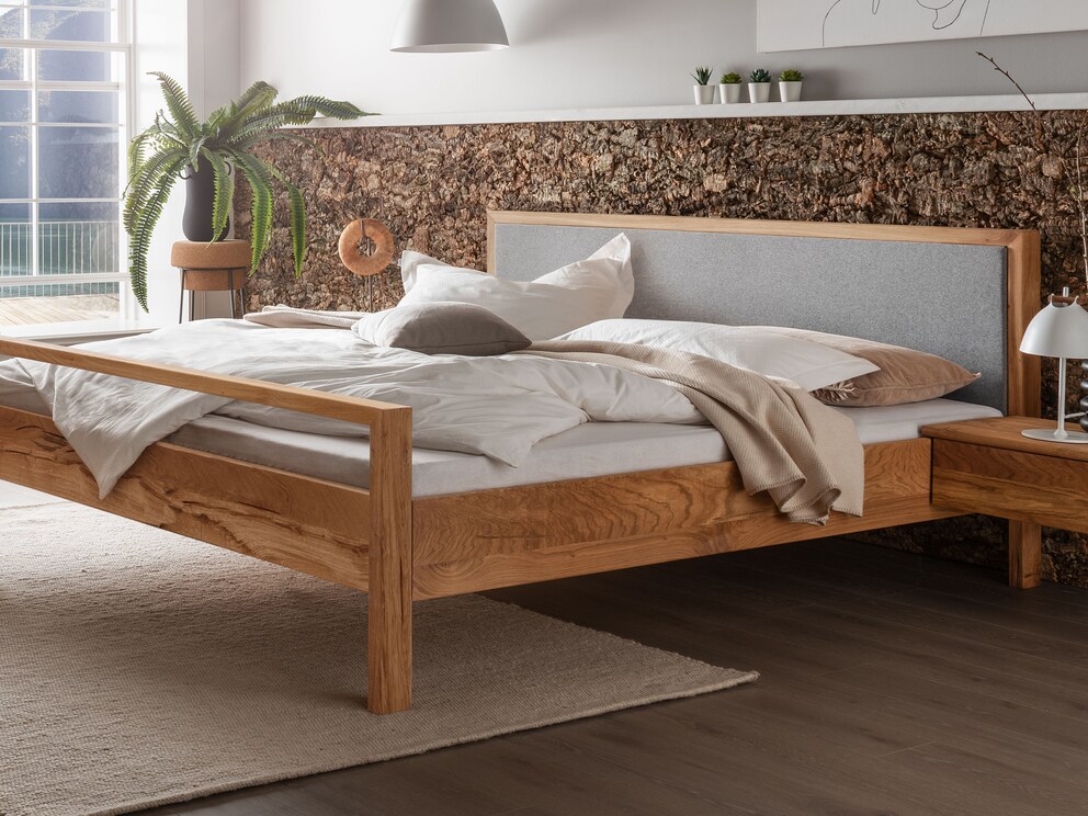 Massief houten bed Capania overtuigt met zijn strakke design, hier met vilten hoofdbord en hoog voeteneind