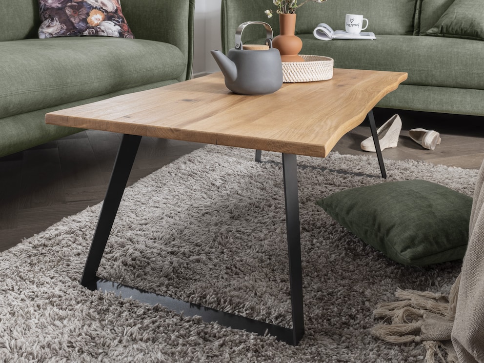 Tijdloze salontafel met opvallend blad van wild eiken en zwart metalen onderstelTijdloze salontafel met opvallend blad van wild eiken en zwart metalen onderstel