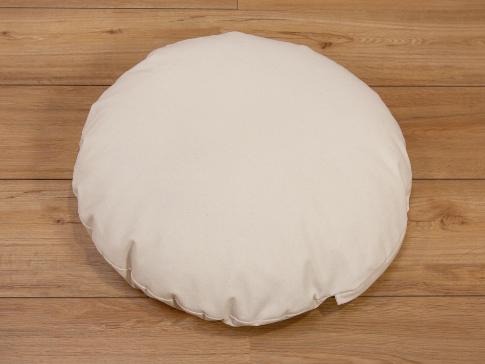 De diamètre 60 cm, le coussin douillet est disponible avec un garnissage en kapok ou vannure d'épeautre