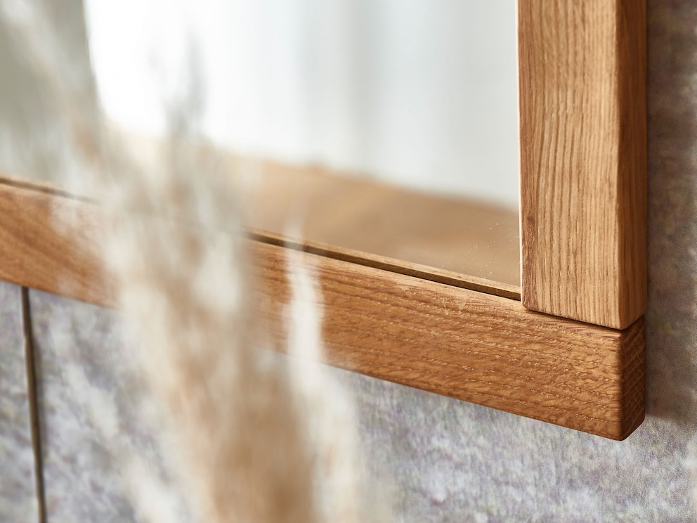 Der schlanke Rahmen des schönen Spiegels ist sorgfältig auf Stoß gearbeitet