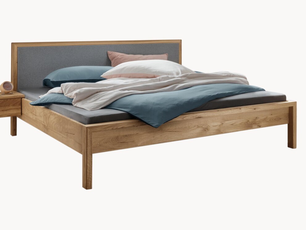 Massief houten bed Capania overtuigt met zijn strakke design, hier met vilten hoofdbord en hoog voeteneind