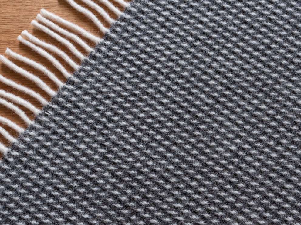 Kleurstelling donkergrijs/wit laat deze knuffelzachte deken uiterst markant en elegant stralen