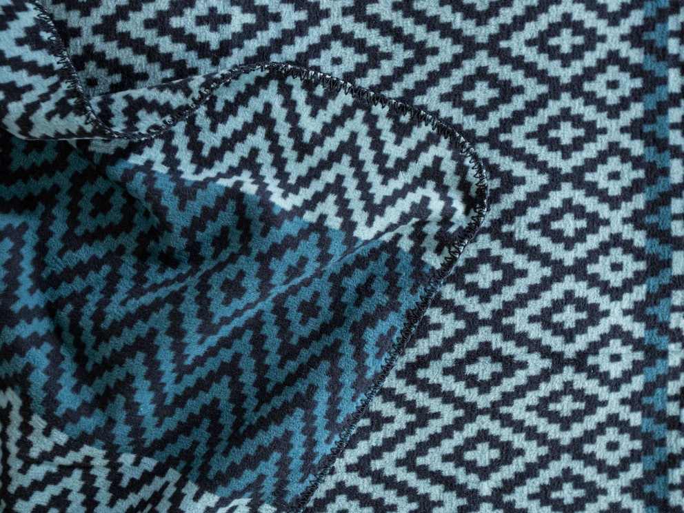 La fascinante couverture réversible est bordée de points décoratifs bleu foncé