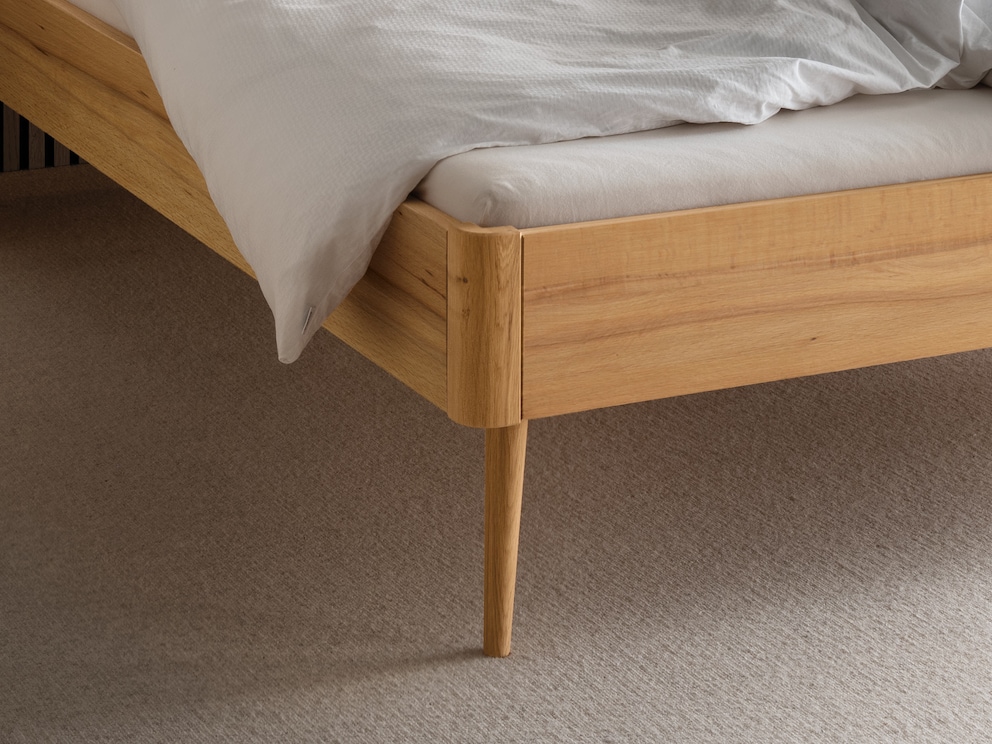 Elegant gevormde poten en afgeronde hoeken geven het bed een moderne vorm