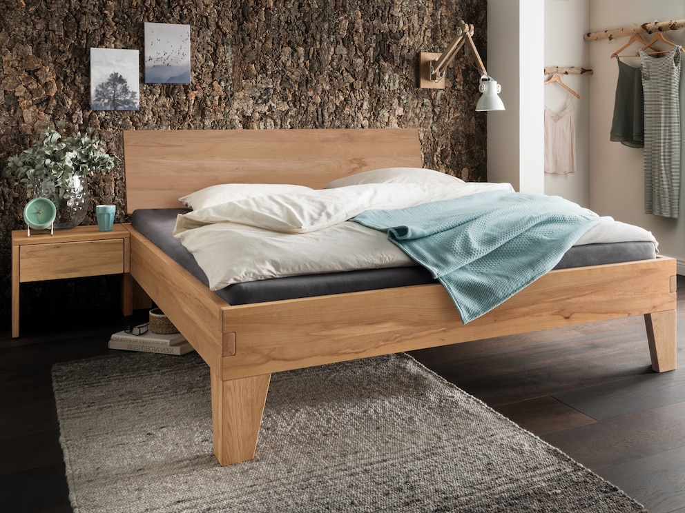 Het massief houten bed Belluno overtuigt met liefdevolle details, hier in levendig kernbeuken