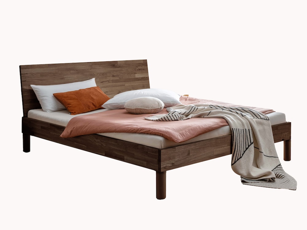 Massivholzbett Lunara schafft eine warme, wohnliche Atmosphäre im Schlafzimmer, hier in Buche Mokka
