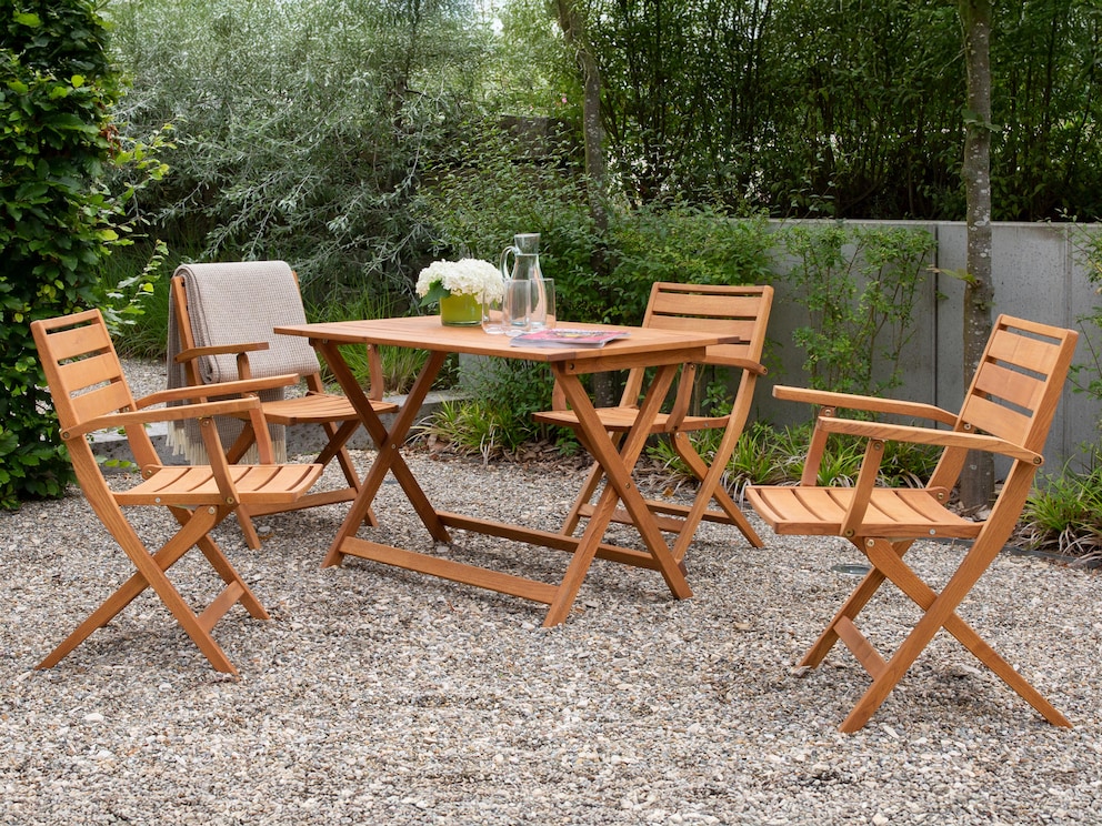 Gemütlicher Gartentisch mit praktischer Klappfunktion, hier mit passenden Armlehn-Klappstühlen Estiva