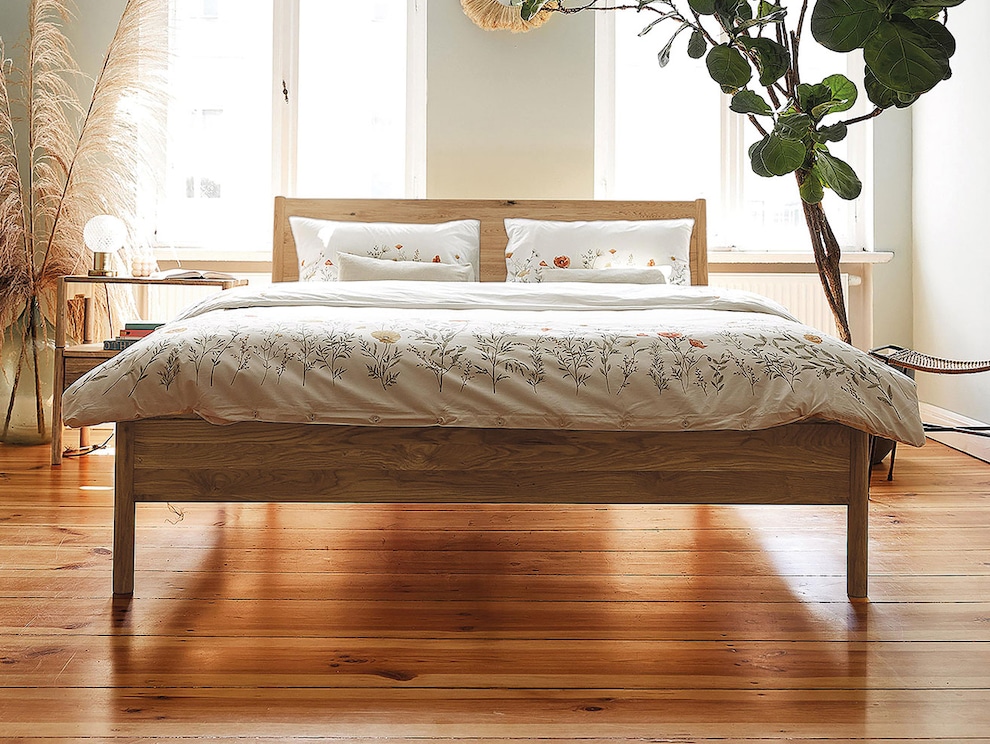 La tête de lit en bois massif rend le lit « Rota » particulièrement élégant