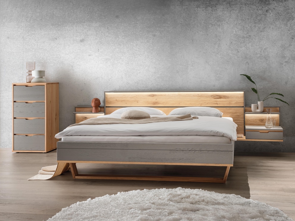 Le lit flottant « Gravia » séduit par ses contrastes de structure et de couleurs, ici en gris avec tables de chevet