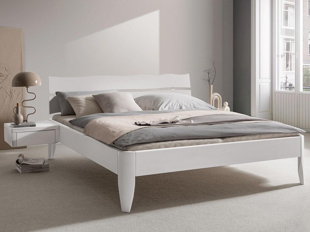 Le lit en bois massif « Candora » séduit par sa forme classique en hêtre laqué blanc moderne