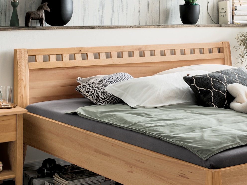 La noble tête de lit présente une finition décorative interrompue et, sur les côtés, un large cadre légèrement bombé.