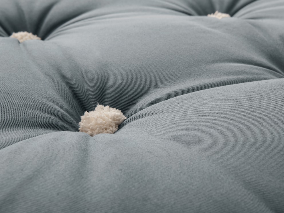 Pluizige, aangenaam zachte viltknopen in natuurlijke kleur benadrukken de casual stijl