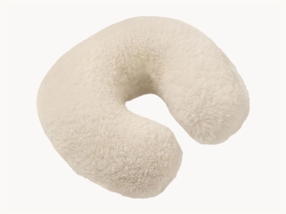 Le coussin cervical en peau d'agneau duveteuse est le compagnon idéal pour les voyages