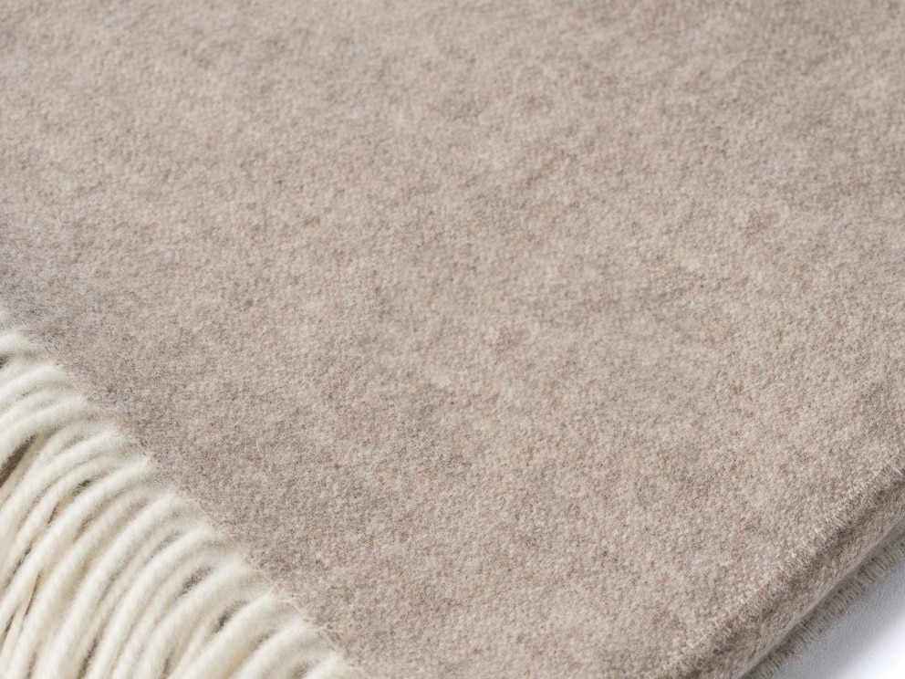 De subtiel contrasterende franjes geven de merino plaid een moderne look