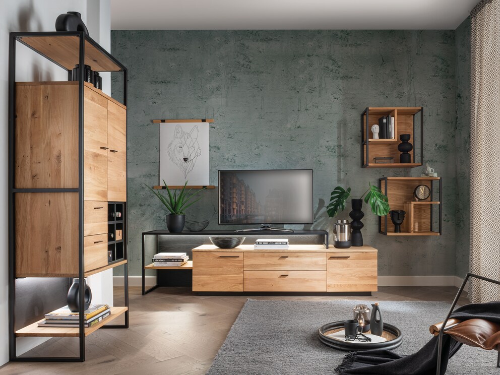 De hoge plank combineert vakkundig de zachte tinten van het hout met koele zwarte metalen accenten